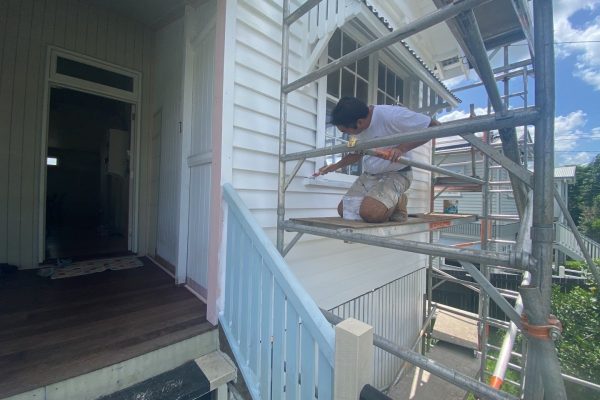 Exterior house painter on scaffolding